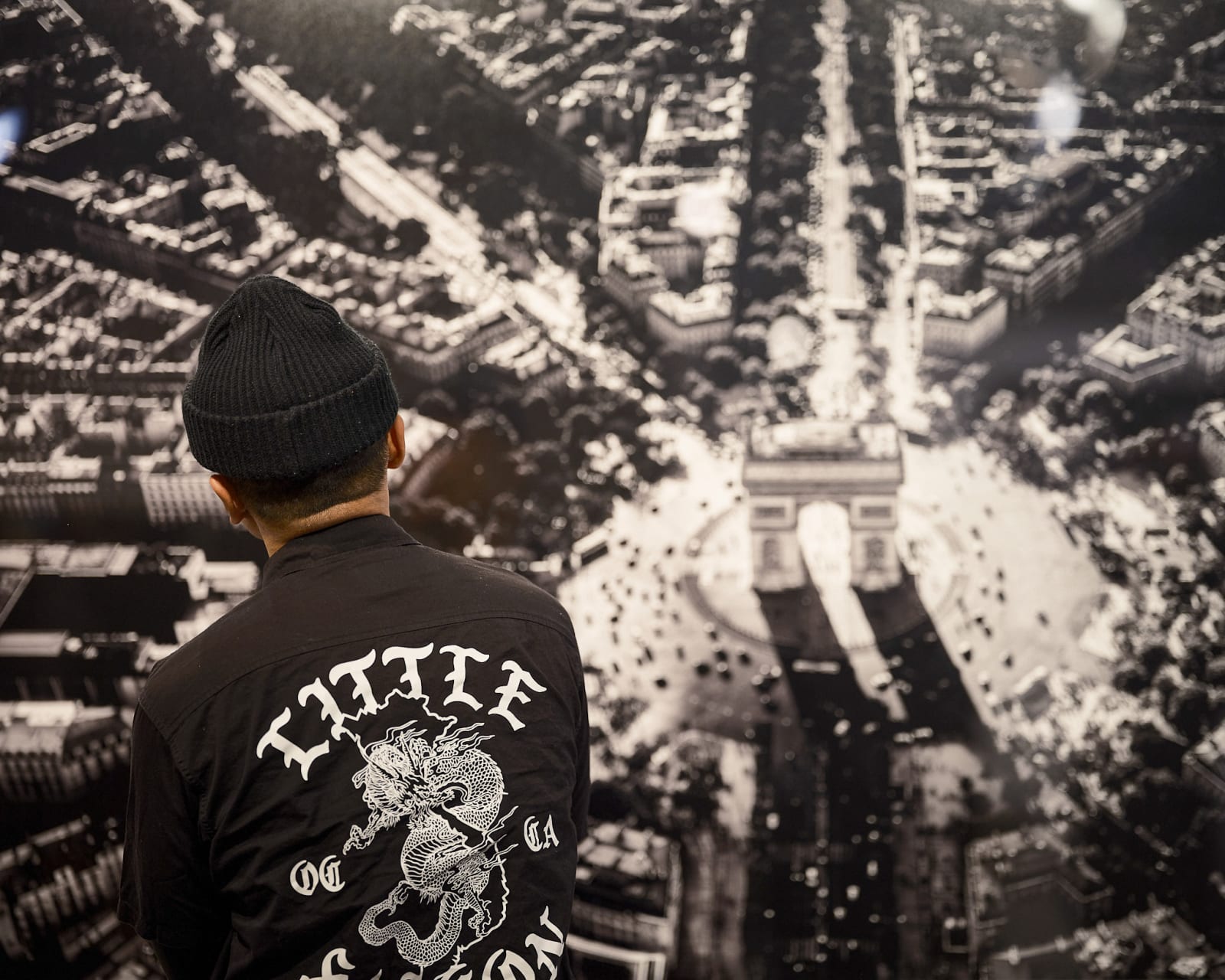 Guest studying a Jason M. Peterson elevated train photograph at luxury Chicago gallery event.