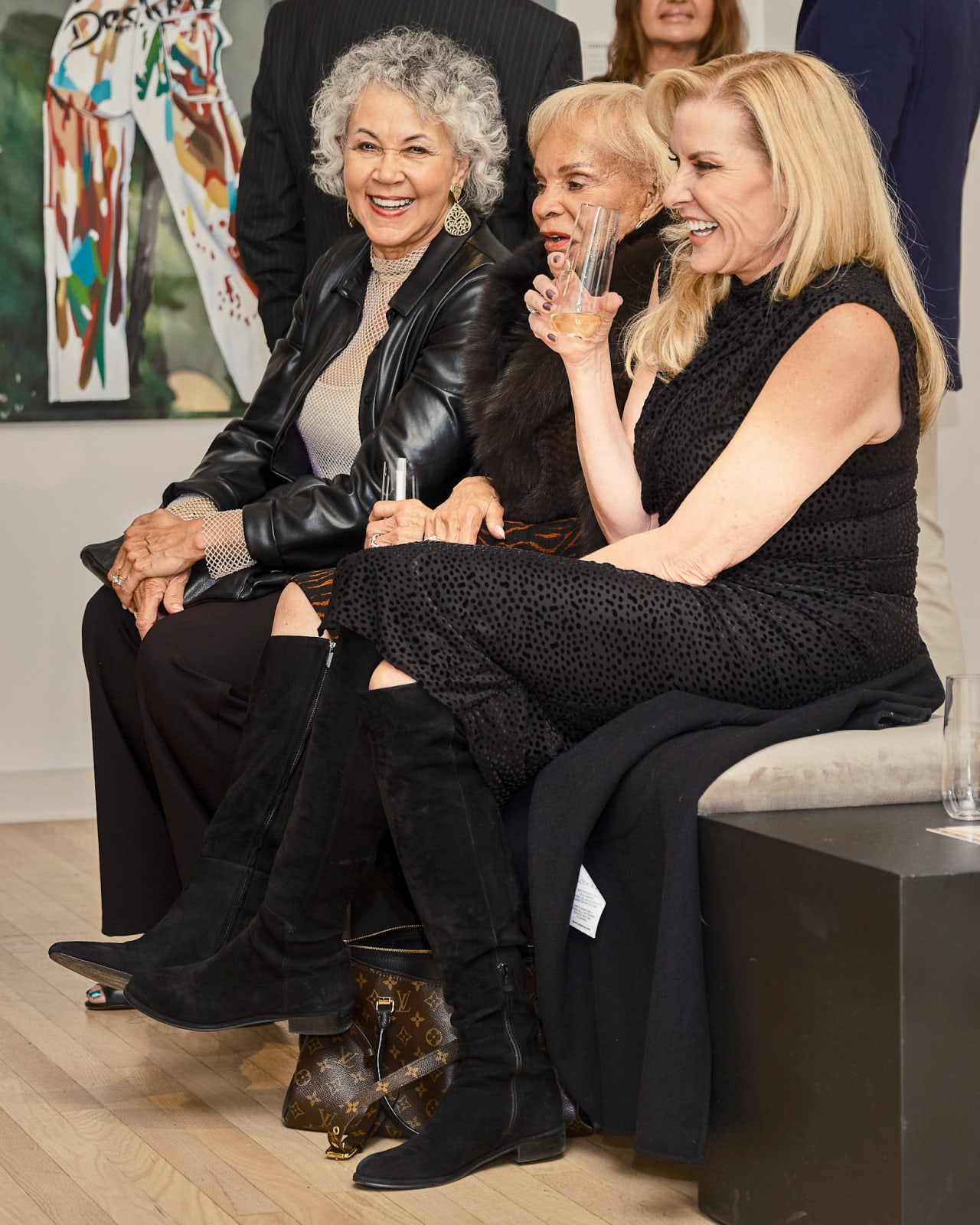 Guests sitting while sharing a joke, reviewing Jason M. Peterson in River North gallery.