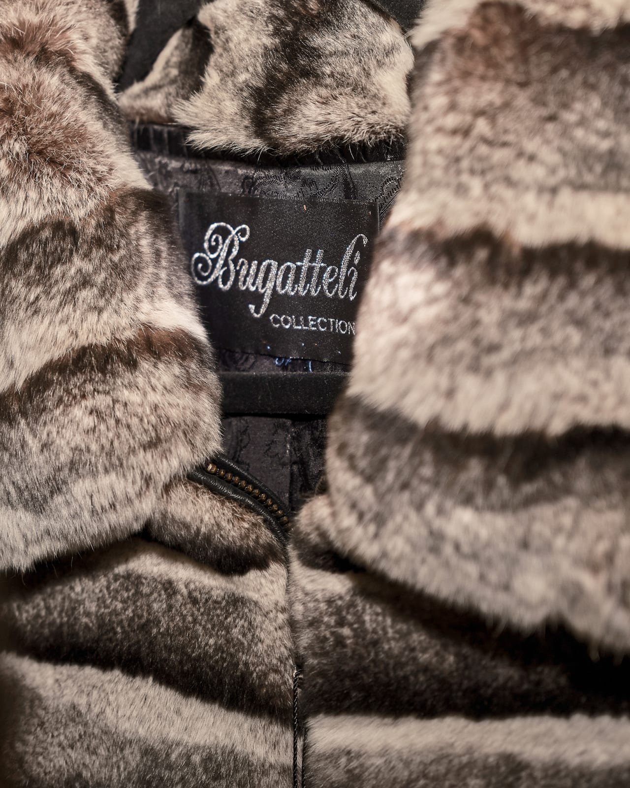 Close-up of luxurious Bugatteli fur coat showing rich texture and high-end craftsmanship at an upscale fashion event.