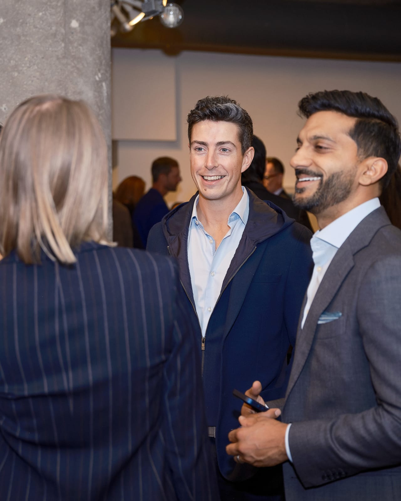 Advisor and client sharing a laugh during a relaxed artwork discussion at Jason M. Peterson Chicago exhibition.