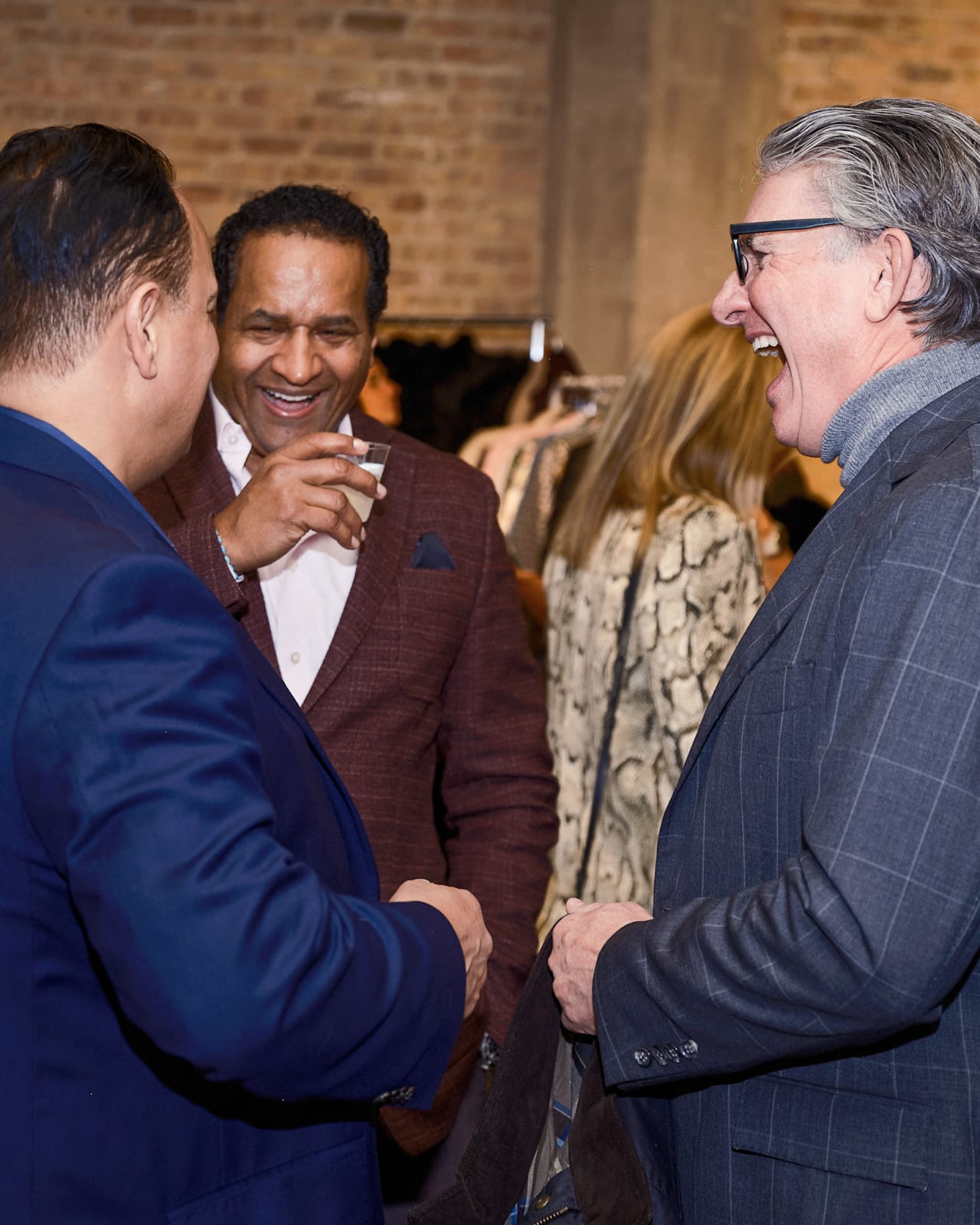 Jason M. Peterson city-at-night photograph hanging above attendees at Chicago gallery reception.