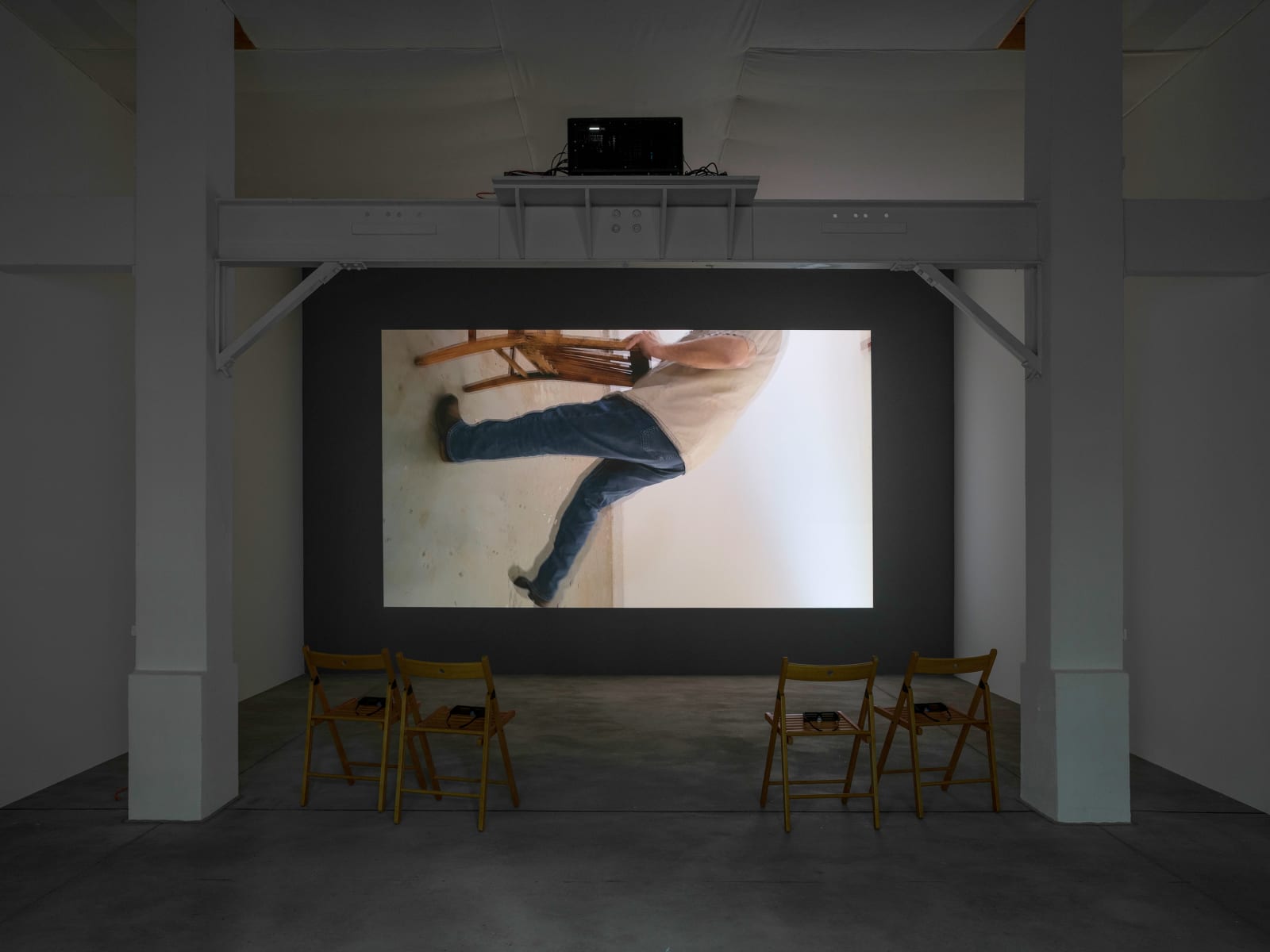 Bruce Nauman Beckett's Chair Portrait Rotated, 2025 3D slow motion video, sound runtime 54 minutes 21 seconds, projection 2.47 x 4.9 m (approx) Installation view, BRUCE NAUMAN Konrad Fischer Galerie, Berlin 2025 Courtesy Konrad Fischer Galerie. © Bruce Nauman/Artists Rights Society (ARS), New York/VG Bild-Kunst, Bonn Photography: Roman März