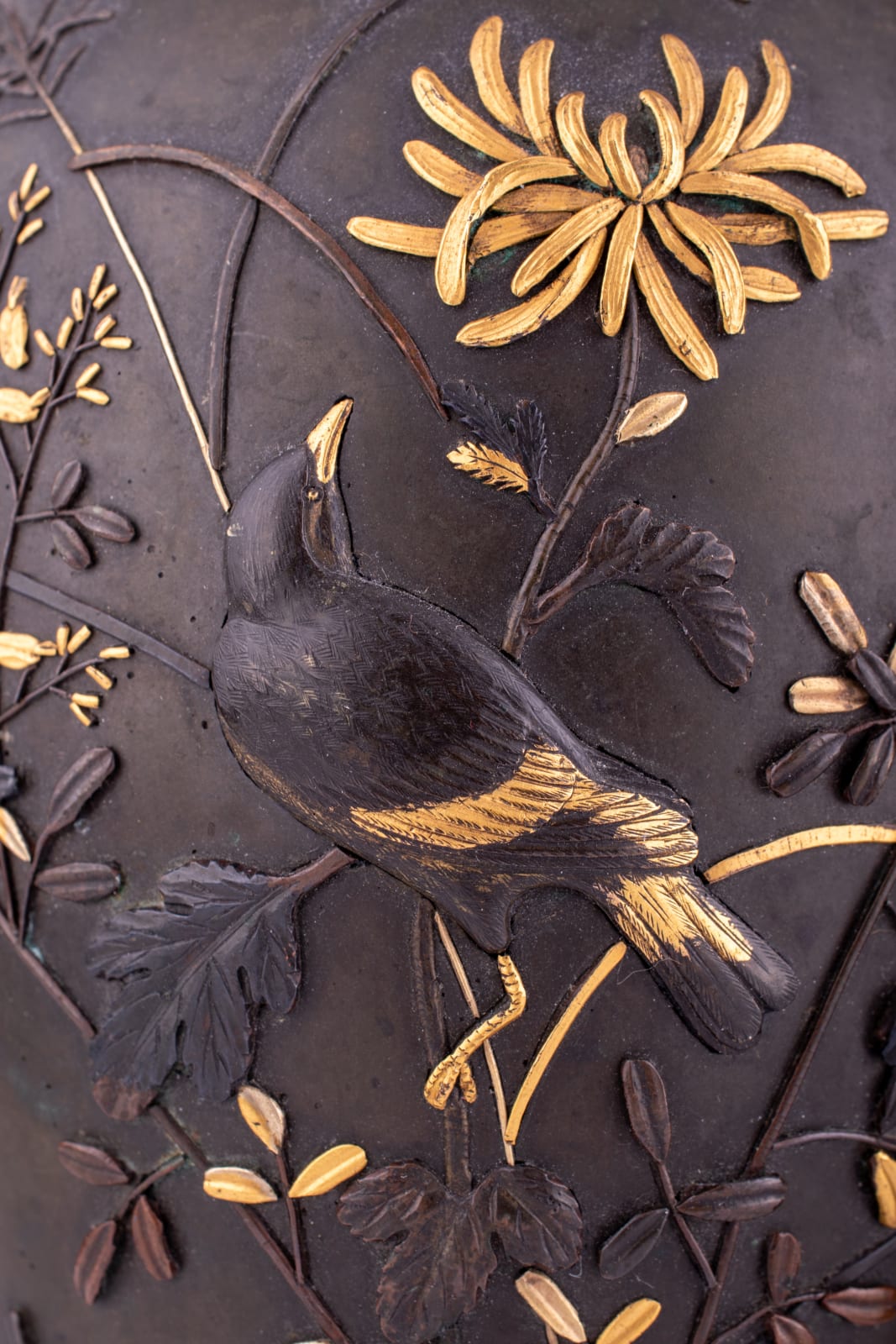 A pair of Japanese baluster vases cast with birds and insects among various flowers