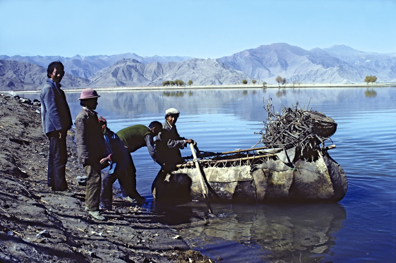 Coracle ferry carrying passengers and wood across the Kyichu Valley to a village not accessible by road on the other side.