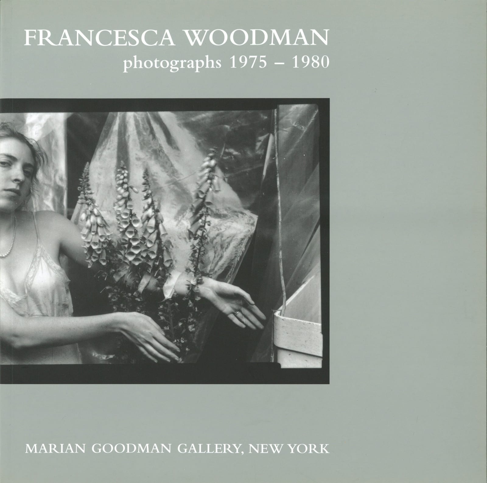 A photo of Francesca Woodman with flowers on the cover of a book.
