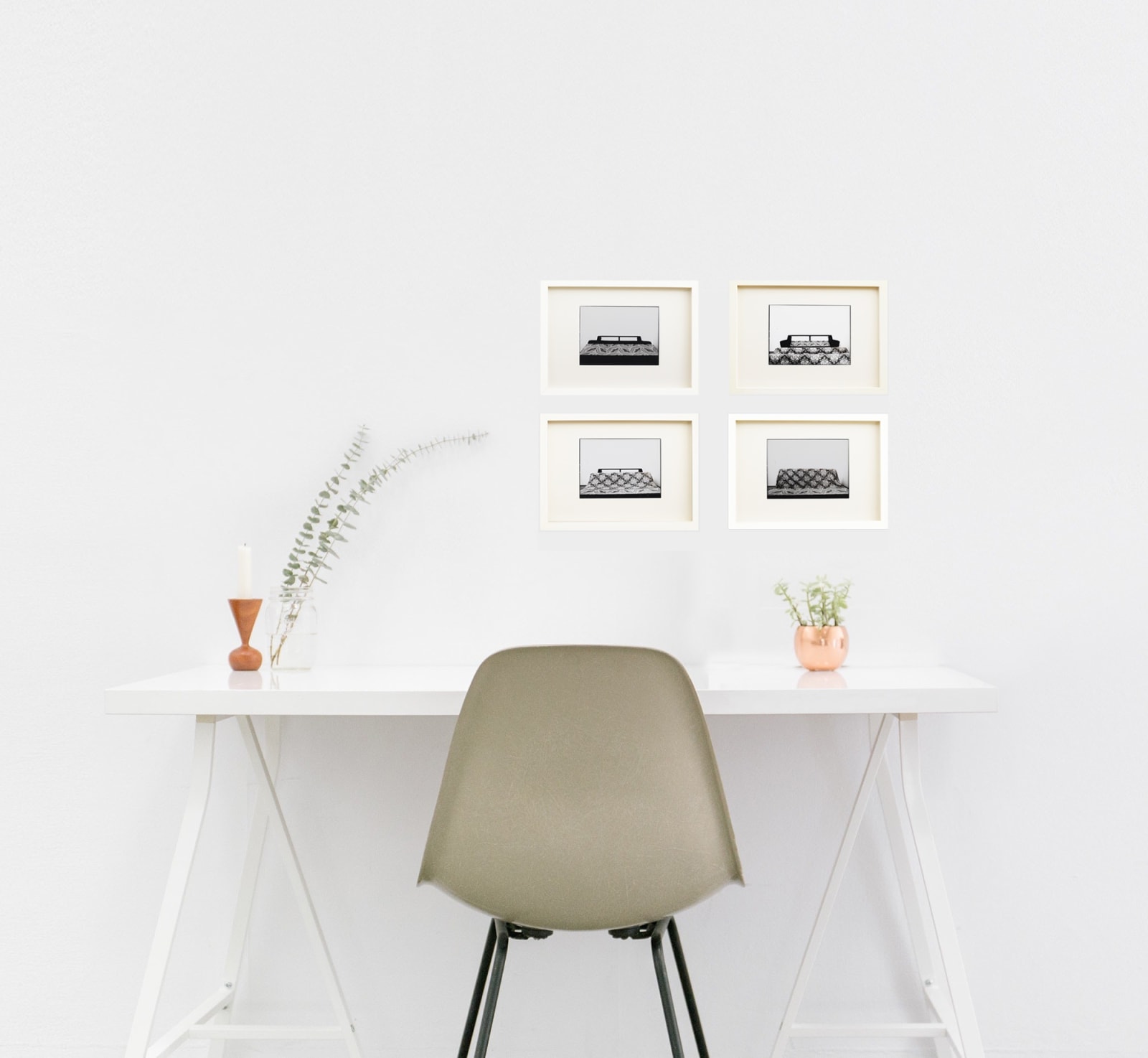 pia mayer mock up showing the series of four framed black and white prints of bed and materials over a desk with chair infront