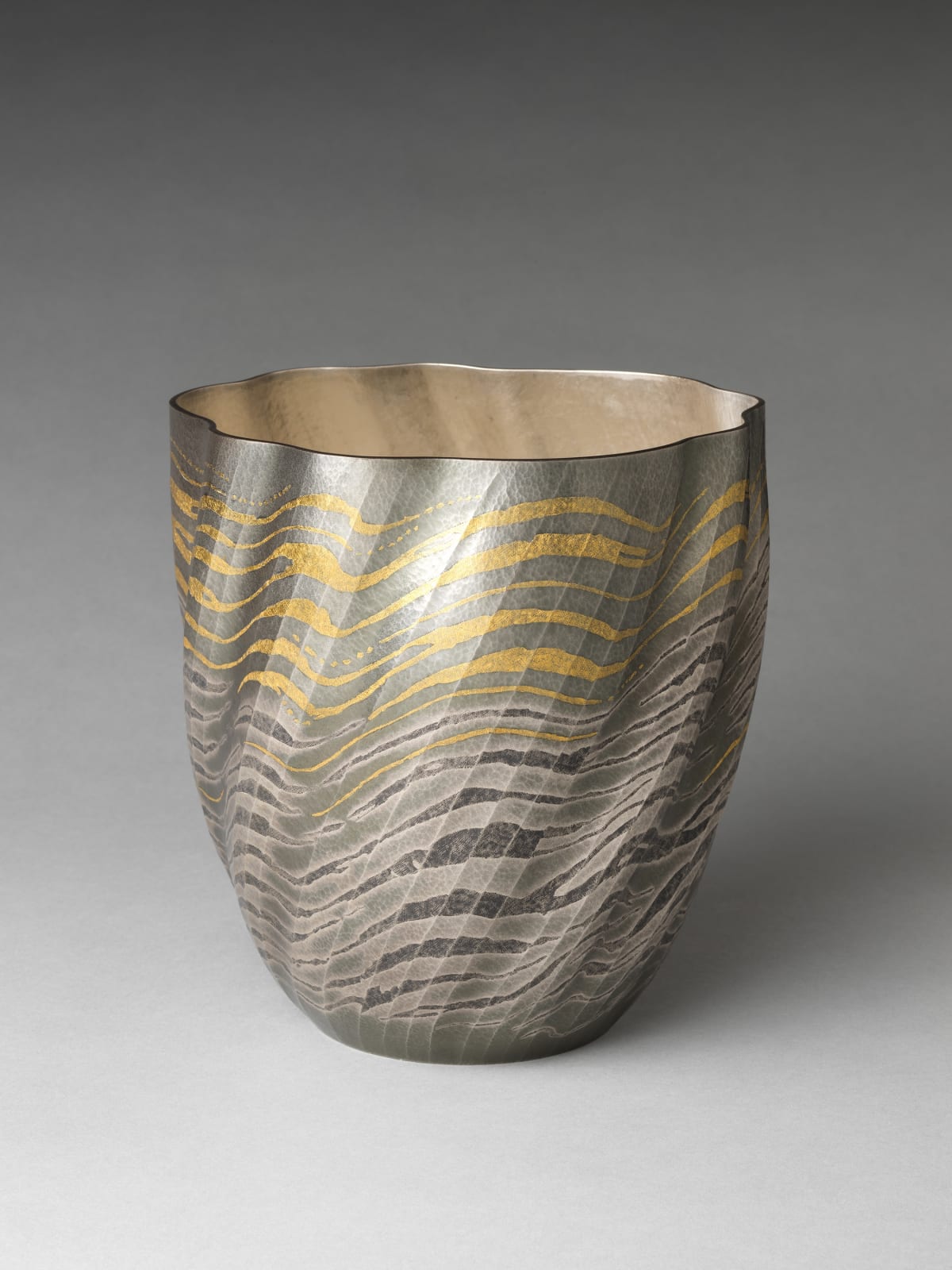 Osumi Yukie (Japanese, born 1945). High Tide Comes In (Shiomitsu), 2007. Heisei period (1989–2019). Hammered silver with nunomezōgan (textile imprint inlay) in lead and gold. H. 9 1/2 in. (24.1 cm); Diam. 9 in. (22.9 cm). The Metropolitan Museum of Art, Gift of Hayashi Kaoru, in celebration of the Museum’s 150th Anniversary, 2020 (2020.76.1)