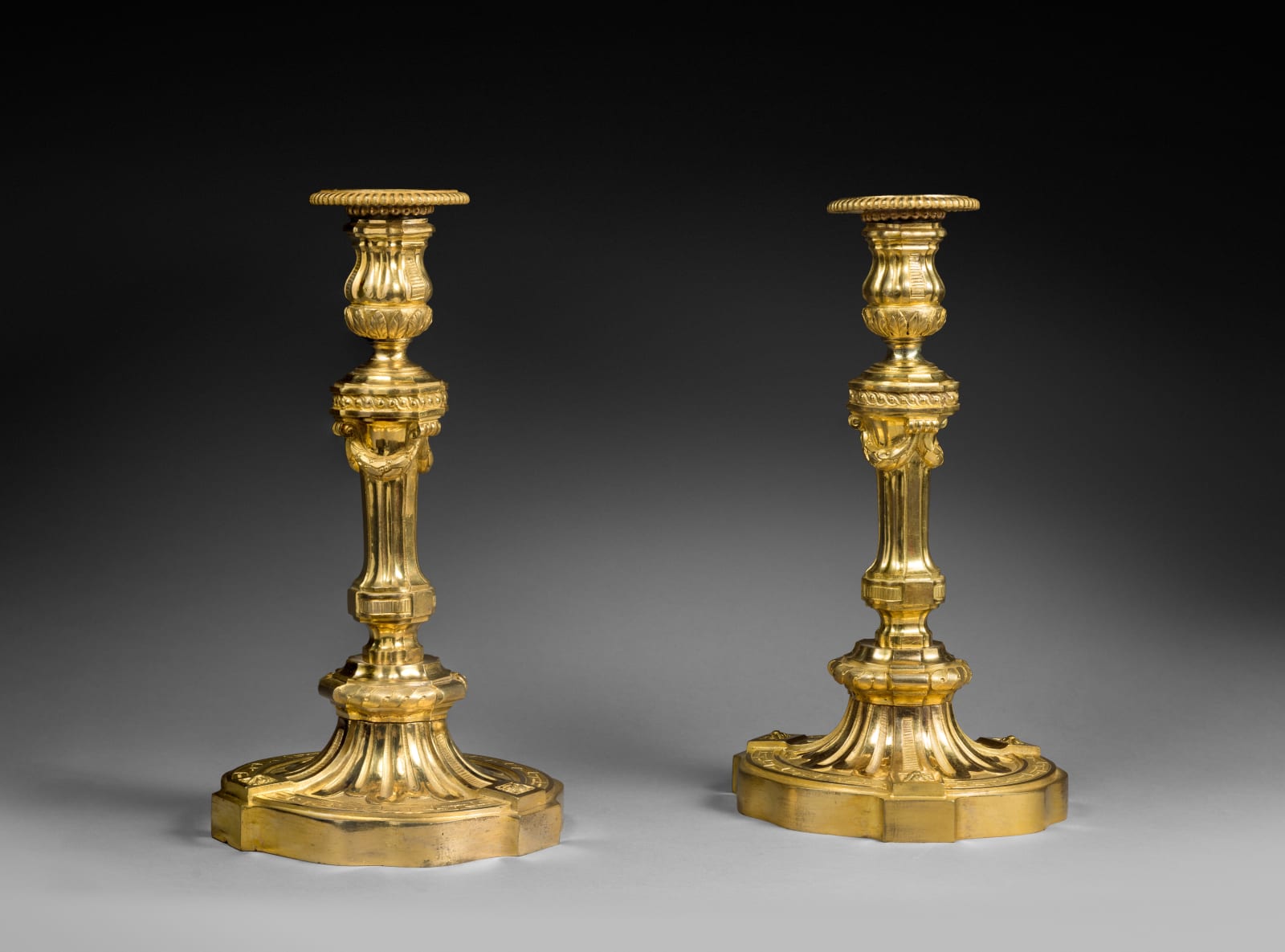 Jean-Charles Delafosse (in the manner), A pair of Transition Louis XV-Louis XVI candlesticks in the manner of Delafosse, Paris, date circa 1770