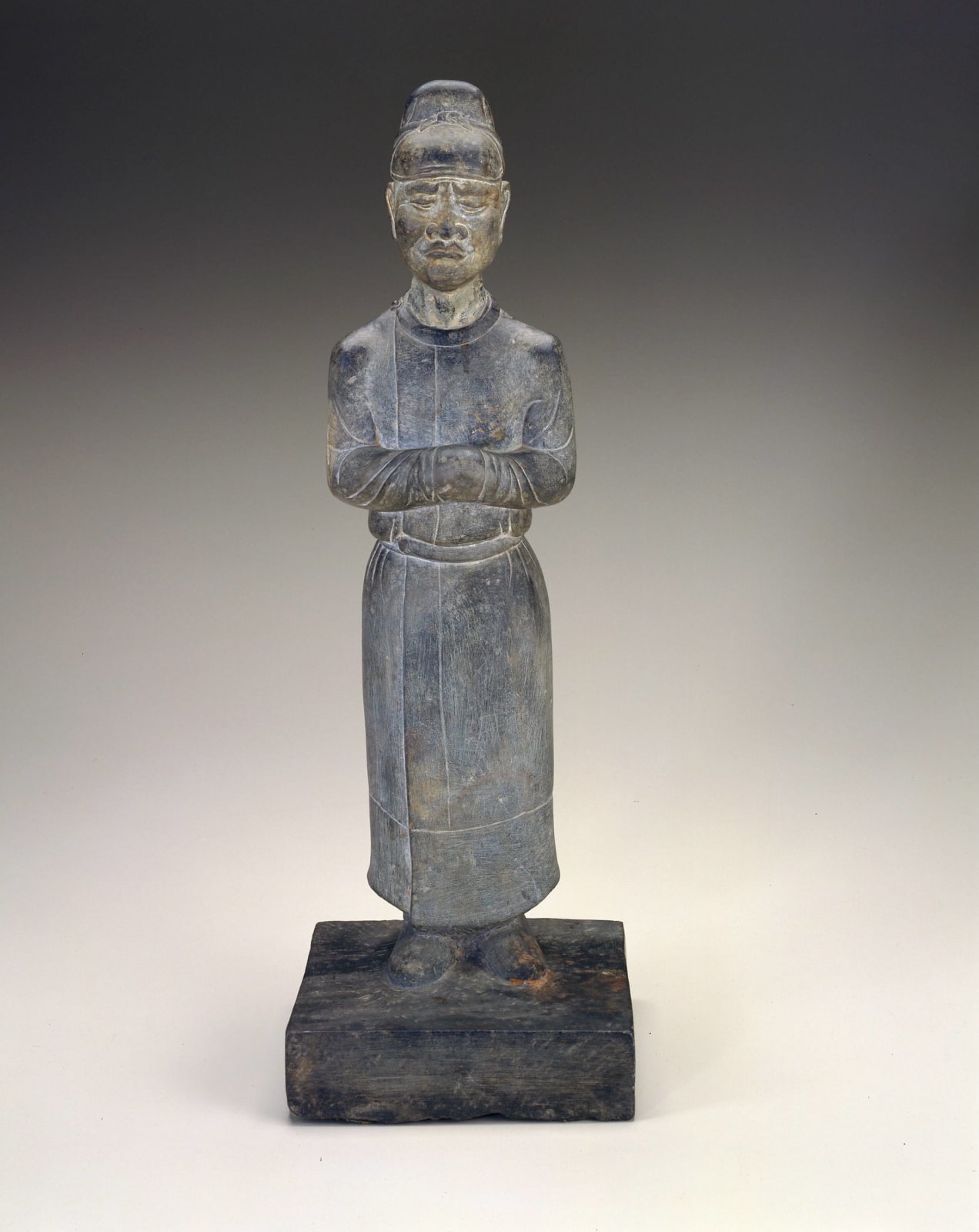 A LIMESTONE FIGURE OF AN ATTENDANT, CHINA, TANG DYNASTY (618 - 907), 7TH CENTURY