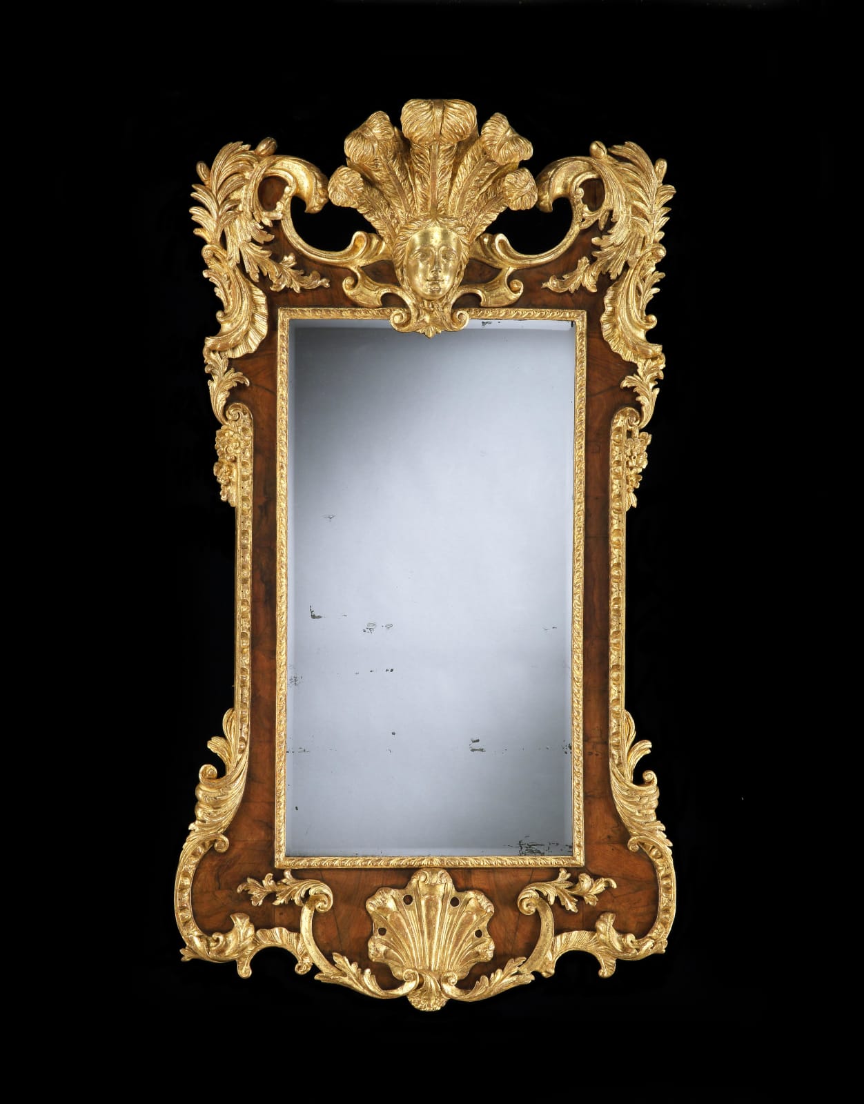 A GEORGE II PARCEL GILT WALNUT VENEERED MIRROR, English, circa 1735