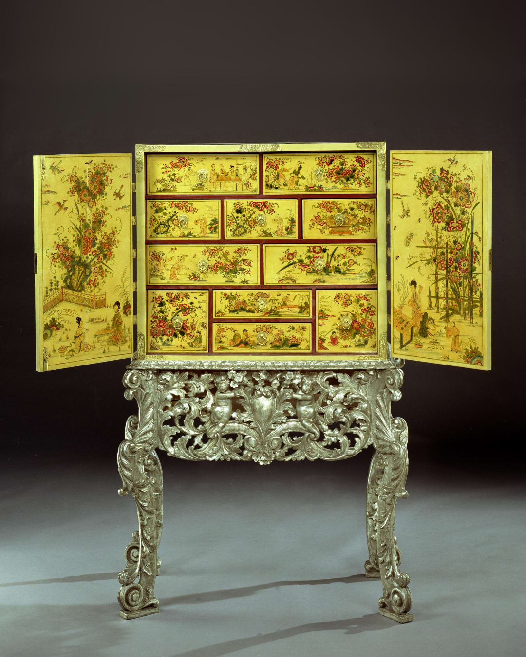 A CHARLES II CREAM JAPANNED CABINET ON SILVERED STAND , English, circa 1680