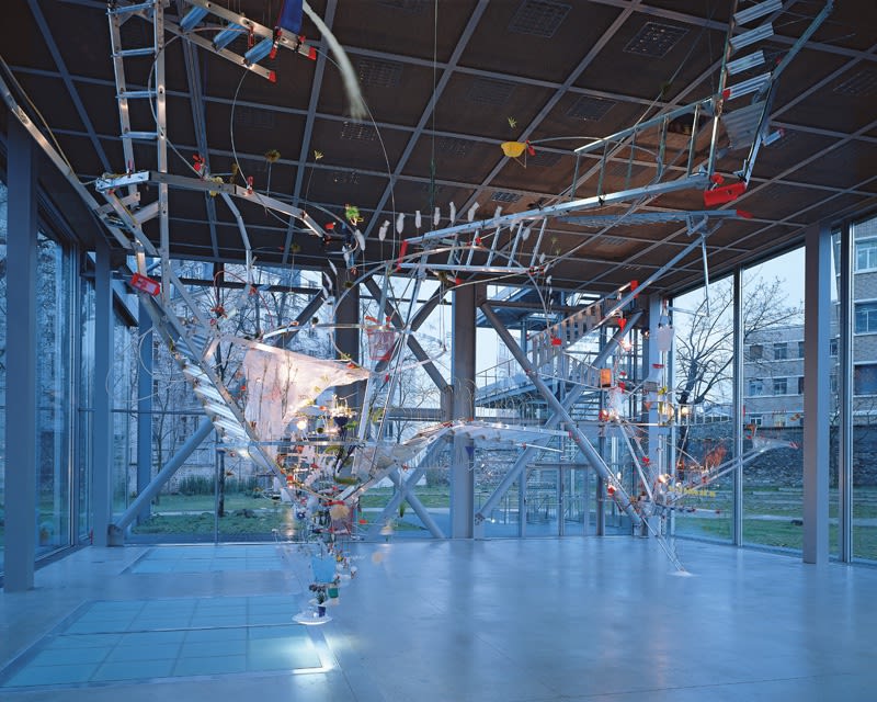 Image of Sarah Sze installation of ladders and other objects circling from ceiling to floor
