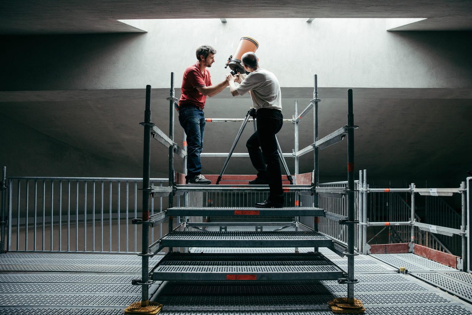 image of two people with a large telescope