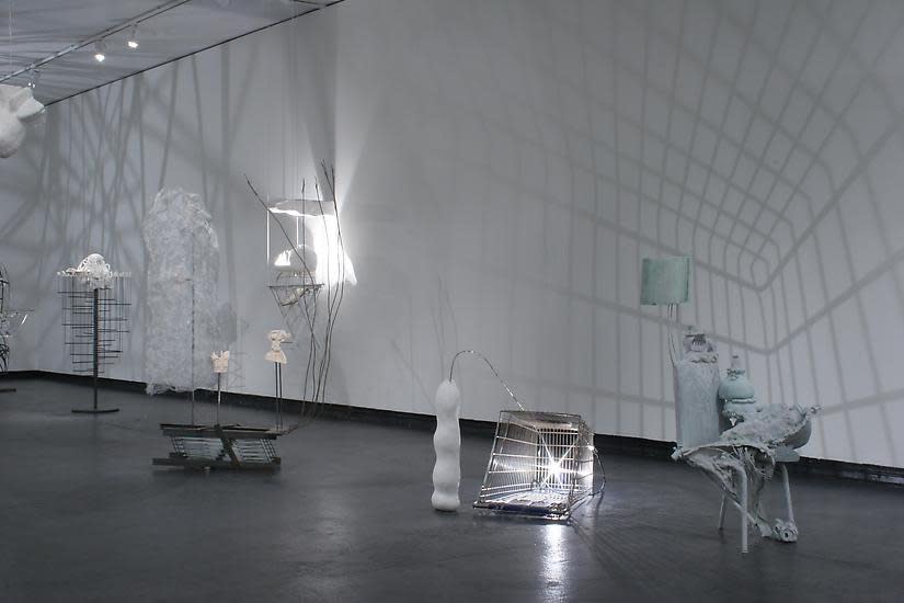image of installation image of multiple Charles Long white sculptures, dim lighting and shadows