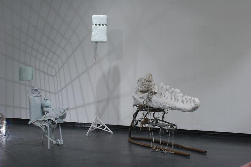image of installation image of multiple Charles Long white sculptures, dim lighting and shadows