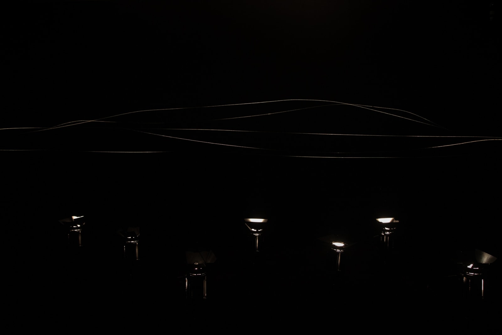 image of spotlit spider webs in dark room