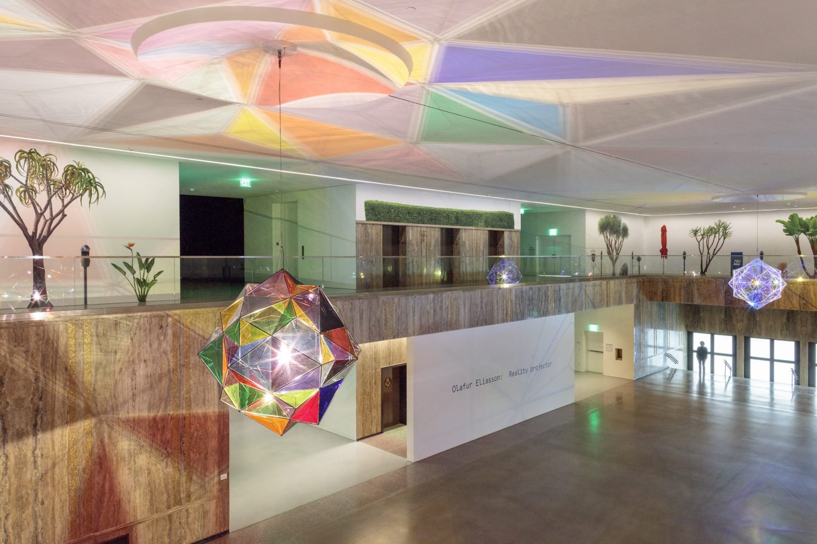 image of installation view, with two large geometric lamps