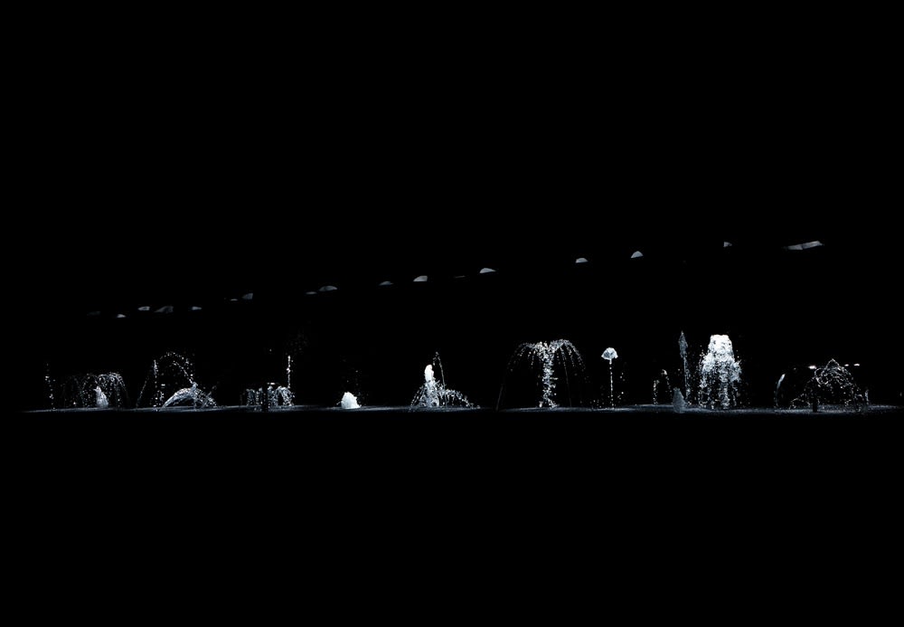 image of dark room with spotlights on water
