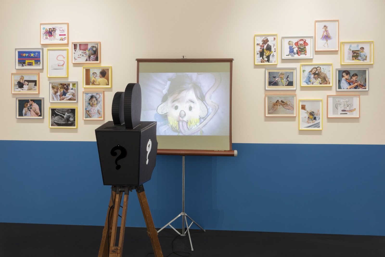 <div class="image_caption_container"><div class="image_caption"><p class="image_caption">Who's Childhood?, 2021, sculptural video installation (cardboard, electrical tape, Plexiglas, antique tripod, projector, projection screen, animation, color, sound), 20 frames: pastel, pencil and inkjet print on paper, 164 x 73 x 73 cm (64 5/8 x 28 3/4 x 28 3/4 in) (projector on tripod), duration: 2:27 min, 24,5 x 33,2 x 3,3 cm (9 5/8 x 13 1/8 x 1 1/4 in) each (15 parts, framed), 33,2 x 24,5 x 3,3 cm (13 1/8 x 9 5/8 x 1 1/4 in) each (5 parts, framed), variable edition of 3 (SF 128). Exhibition view: Simon Fujiwara, Once Upon a Who?, Esther Schipper, Berlin (2022). Photo © Andrea Rossetti</p></div></div>