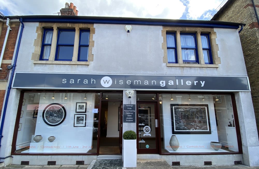 A view of Sarah Wiseman Gallery from outside. It's sunny weather and the windows display new works by Ade Adesina
