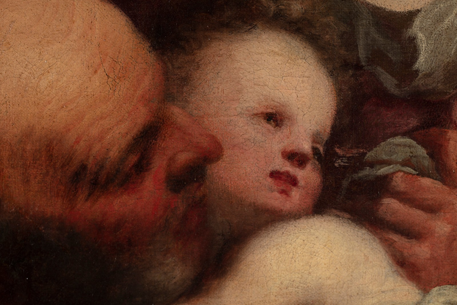 A detail of an oil painting of the Holy Family, the Child Jesus, the Virgin Mary and Saint Joseph, set in a natural landscape. The detail shows the face of St Joseph and baby Jesus.