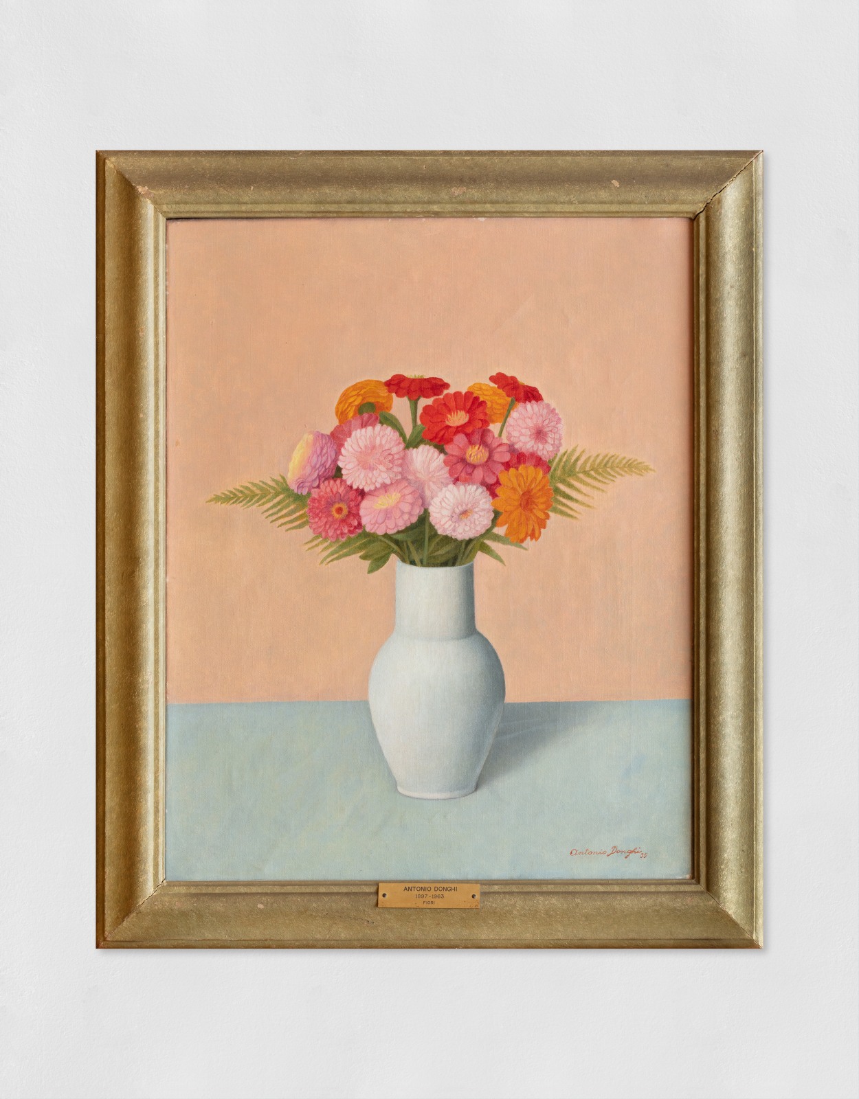 An oil painting of bright pink and orange flowers in a blue vase sat on a blue table with a pink background.