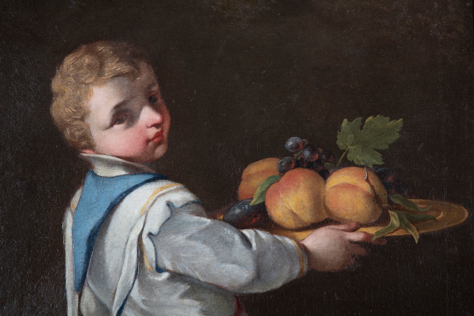 Detail of an oil painting of a young boy with a fruit platter.