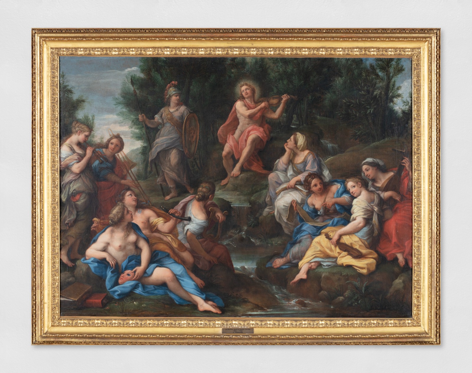An oil painting of The Parnassus, a mountain in central Greece adjacent to the site of the ancient city of Delphi that in Greek mythology was sacred to Apollo and the Corycian nymphs and the home of the Muses. Apollo stands off to the left in his military garb while the Corycian nymphs play music and the muses recline in the foreground around a stream.