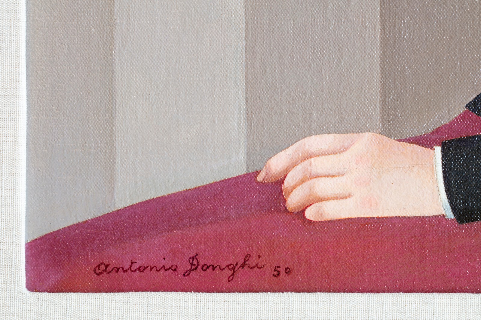 Detail of an oil painting of a woman smoking. Dressed in a black jacket and red bottoms, sat against a pink wall. The detail shows the artist’s signature.