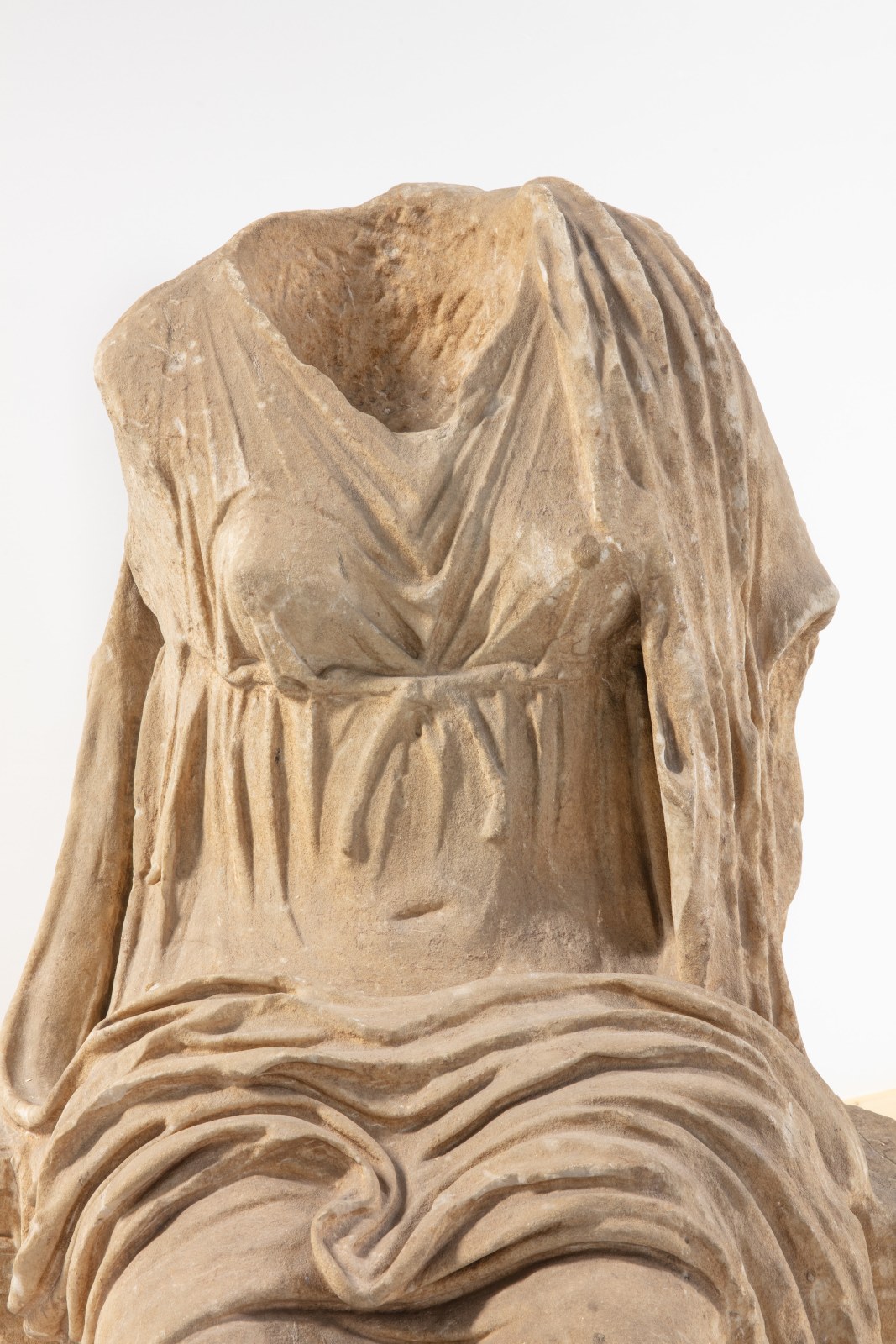 Marble sculpture of a headless female figure.