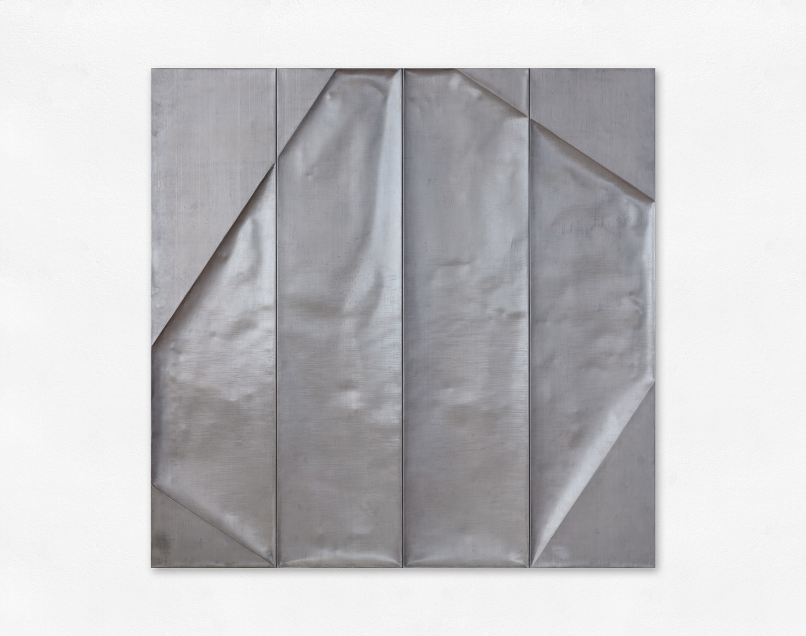 A wall sculpture made of lead moulded over a wooden structure.