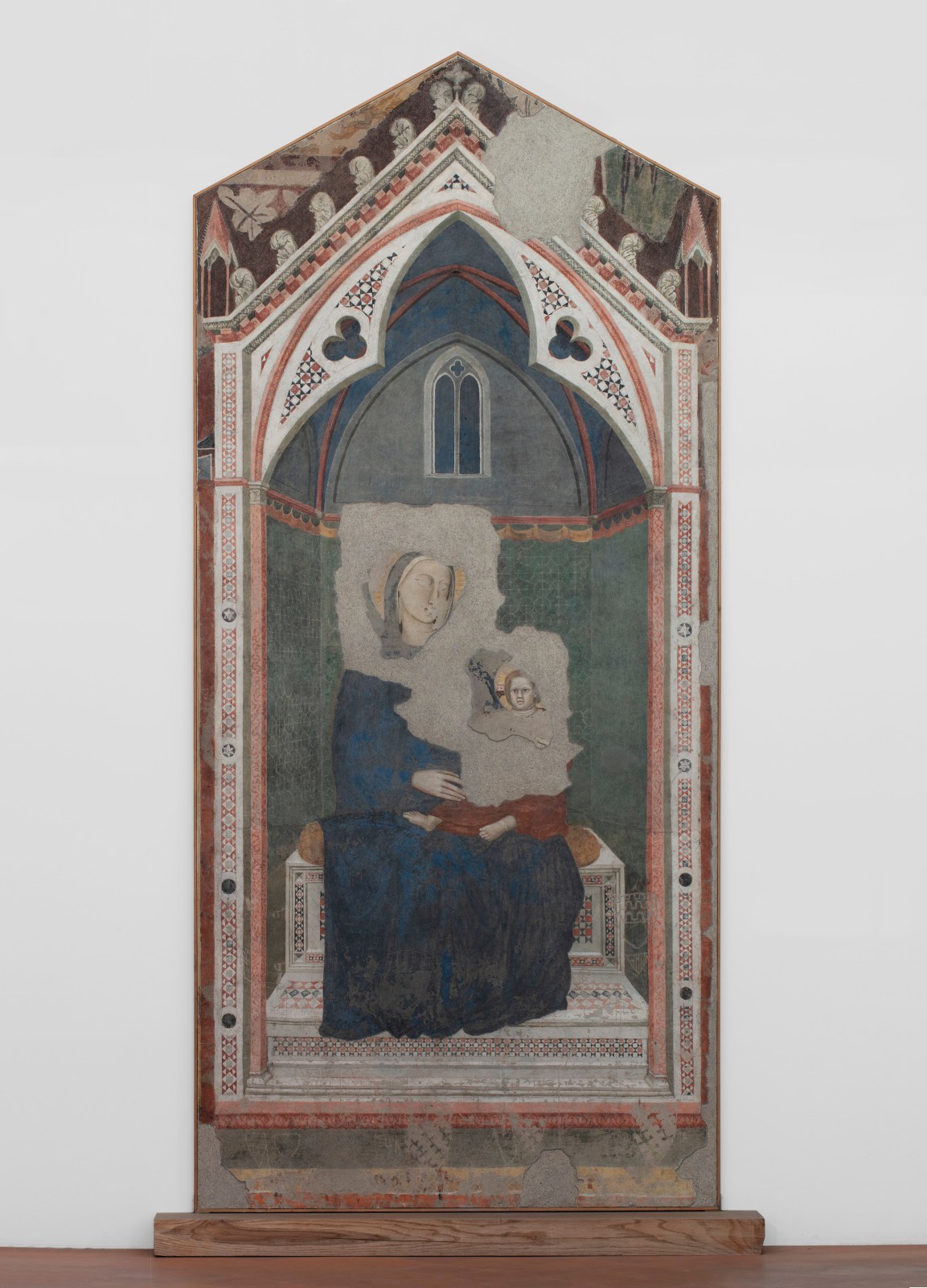 A ripped fresco of the Virgin Mary in Majesty holding Jesus Christ. Artwork details: Artist: Giotto di Bondone (collaborator). Artwork title: Madonna in Maestà. Artwork date: 1300. Artwork medium: Ripped fresco. Artwork dimensions: 350 x 160.5 x 3.5 cm.