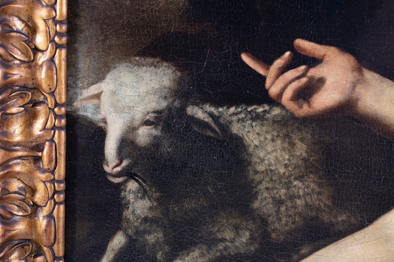 Detail of an oil painting of San Giovannino with a sheep.