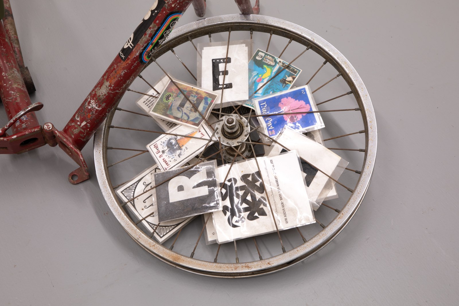 Detail of Daid Roy, Bianchi Folder, 2005-2025. Folding bike frame, Glock field knife, 20" wheels, spoke cards, rack, motorcycle handlebars, hoseclamp, safety wire. 33 x 26 x 40 in (83.82 x 66.04 x 101.60 cm).