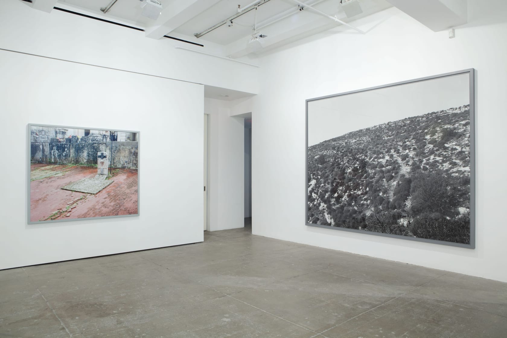 An image of a run down grave stone hangs next to a black and white image of a hill covered in grass and shrubs. 