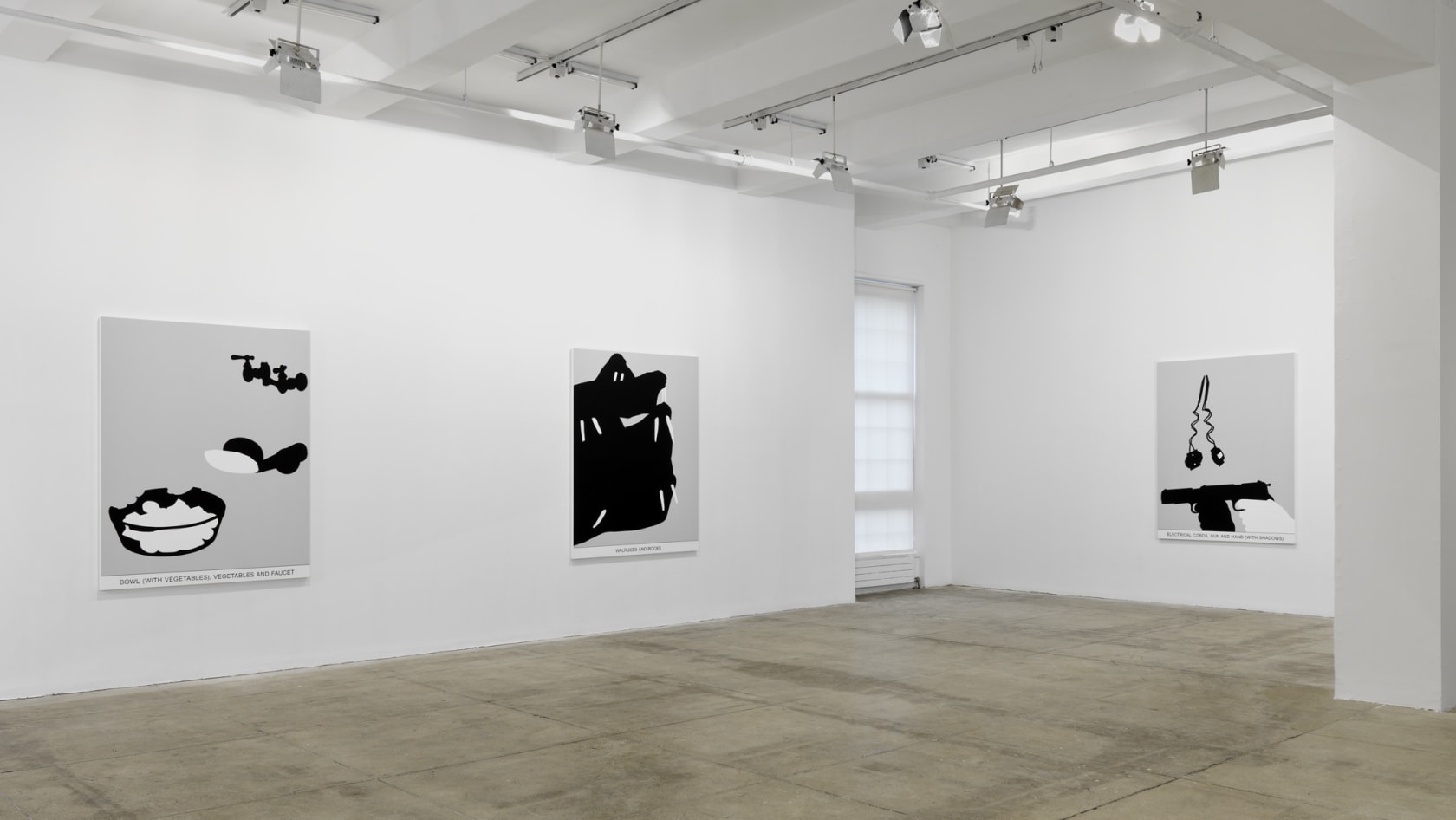 Three black and white paintings hang in a white space with a beige floor.
