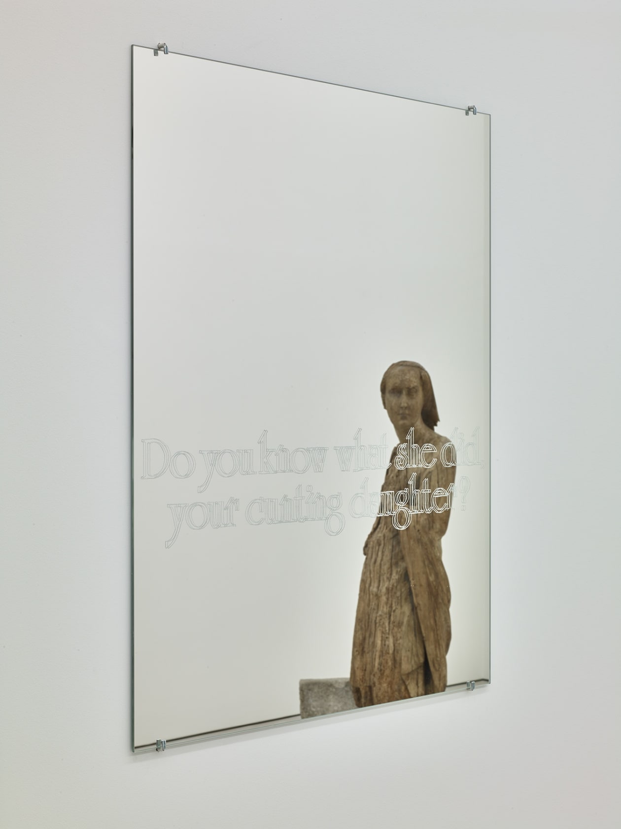 Image of mirror with translucent words reflecting a figurative statue facing the mirror.