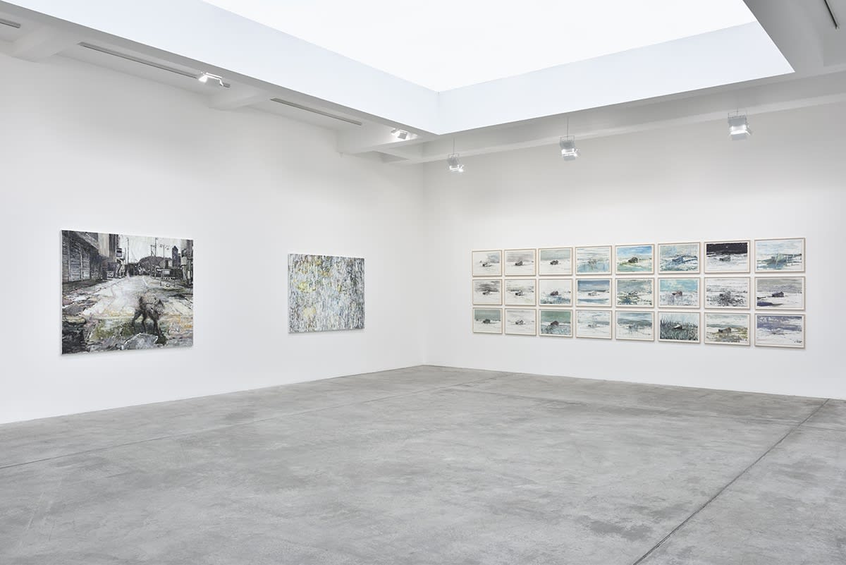 In a large white space, several expressionist oil paintings of various sizes and subjects hang.