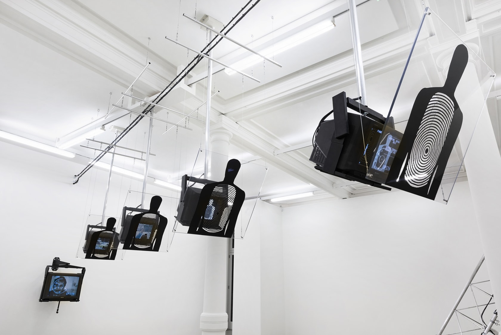 5 TVs hang from the ceiling with shooting targets shaped like the human form placed in front.