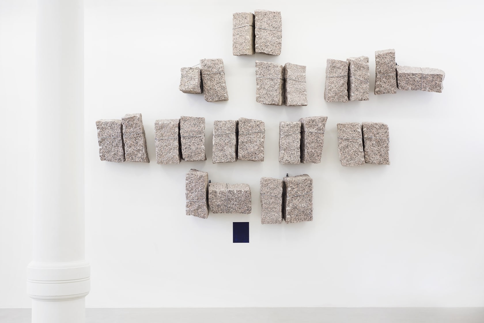 Small blocks of granite tied together and installed on wall.