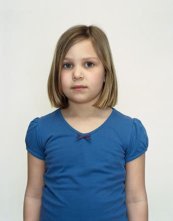A Rineke Dijkstra portrait of a young girl in a blue shirt.