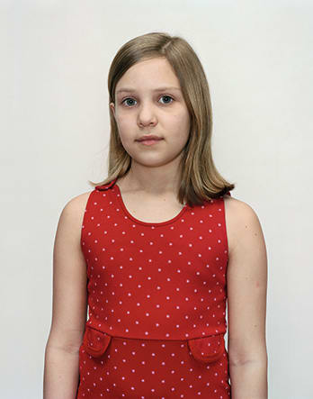 A Rineke Dijkstra portrait of a girl in a red polka dot dress.
