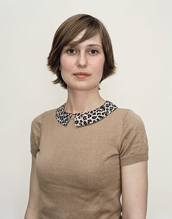 A Rineke Dijkstra portrait of a woman in a beige blouse with short hair.
