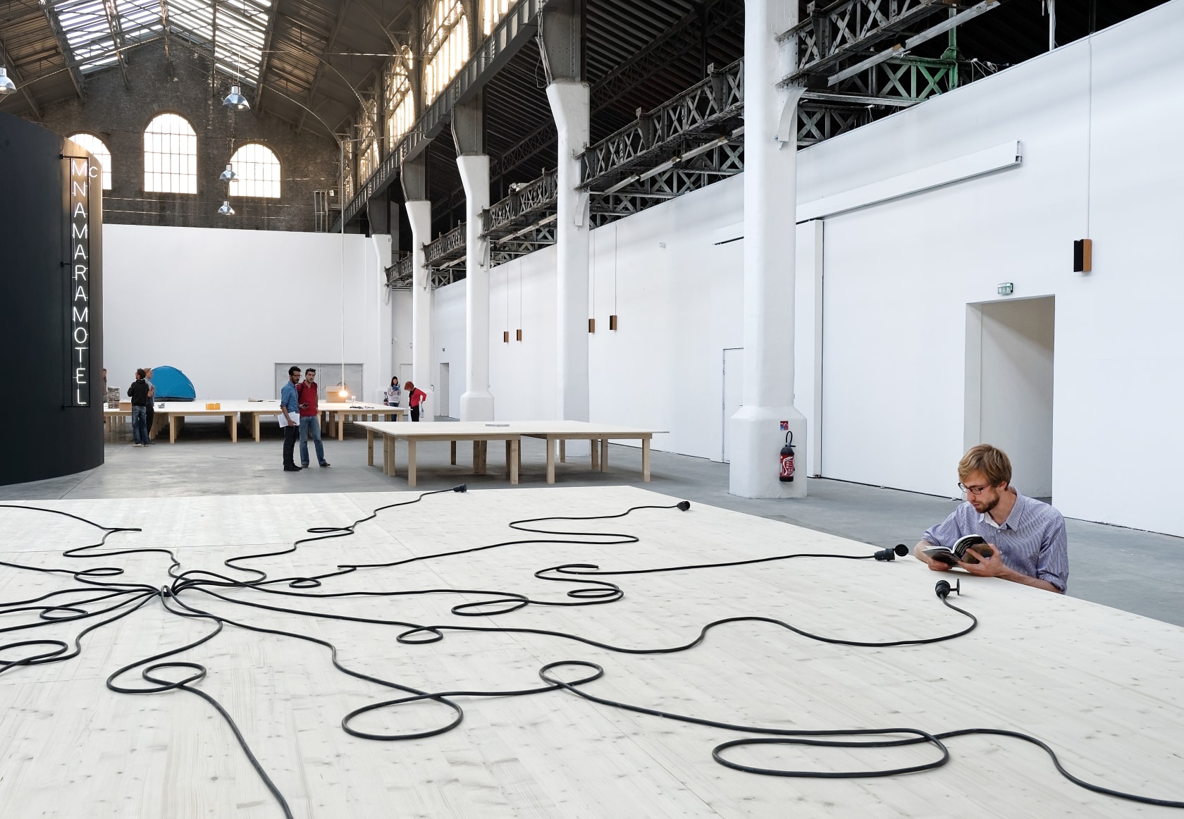 McNamara Motel, 1997 (left) white neon, metal structure Prototype Erasmus Table #2 (Gent), 1994 (front) Prototype Ibuka! Coffee Table/Stage (Act3),...