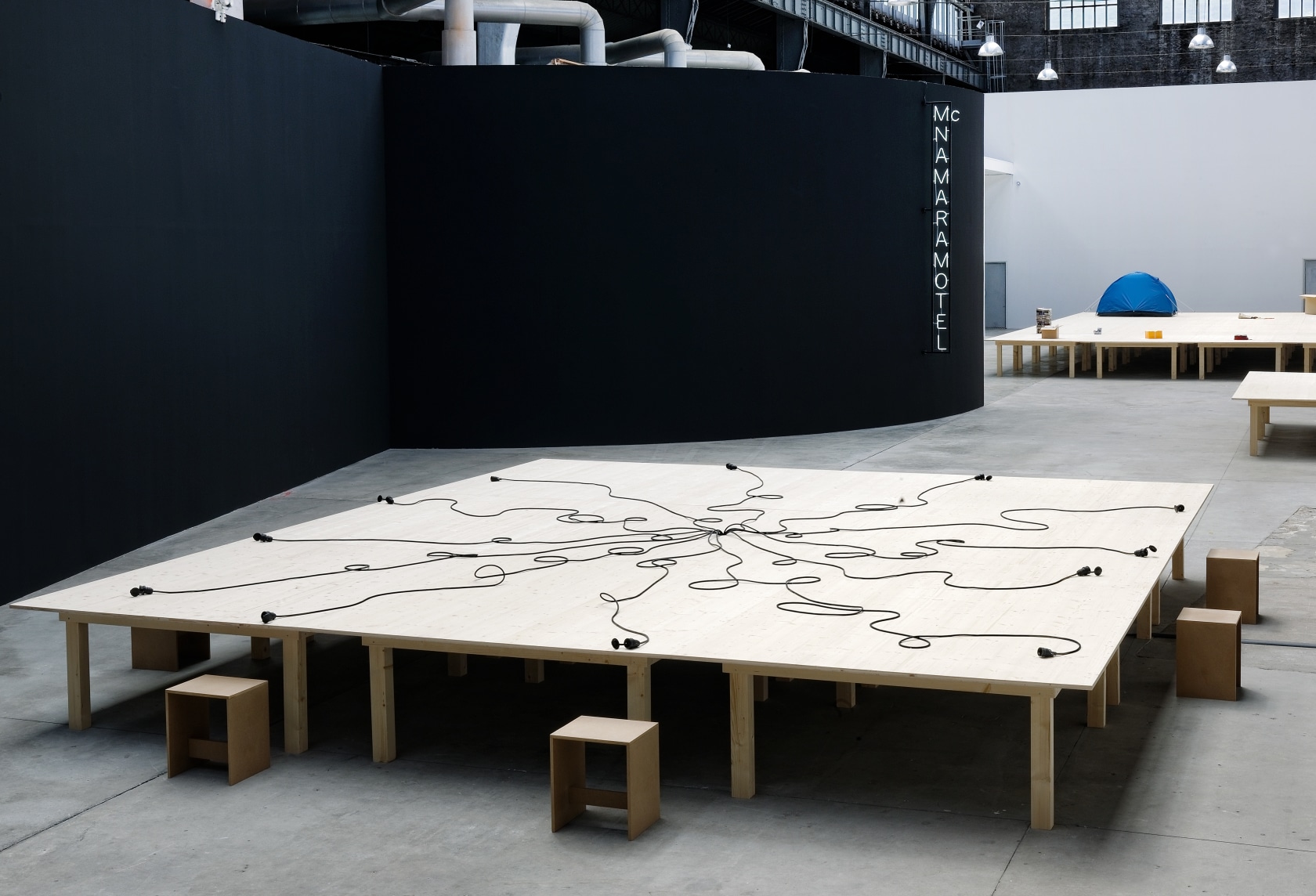 Prototype Erasmus Table #2 (Gent), 1994 (front) McNamara Motel, 1997 (back) White neon, metal structure Prototype Ibuka! Coffee Table/Stage (Act3),...