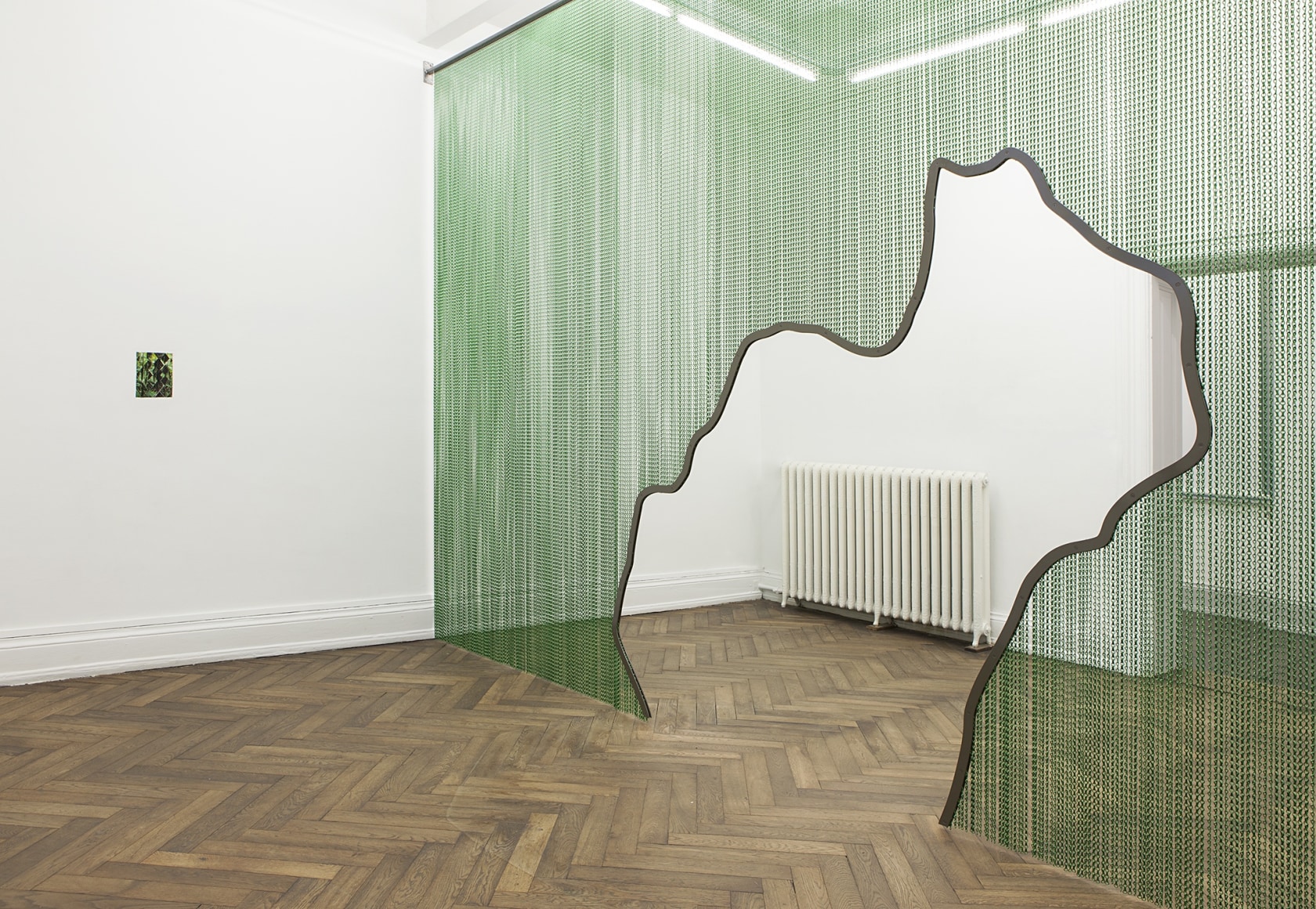 Kiti Ka’aeté (reverse), 2011 (left) Slide projector, laser-cut steel slide, wall, hole, collage The collage, assembled from realigned rhomboid sections...