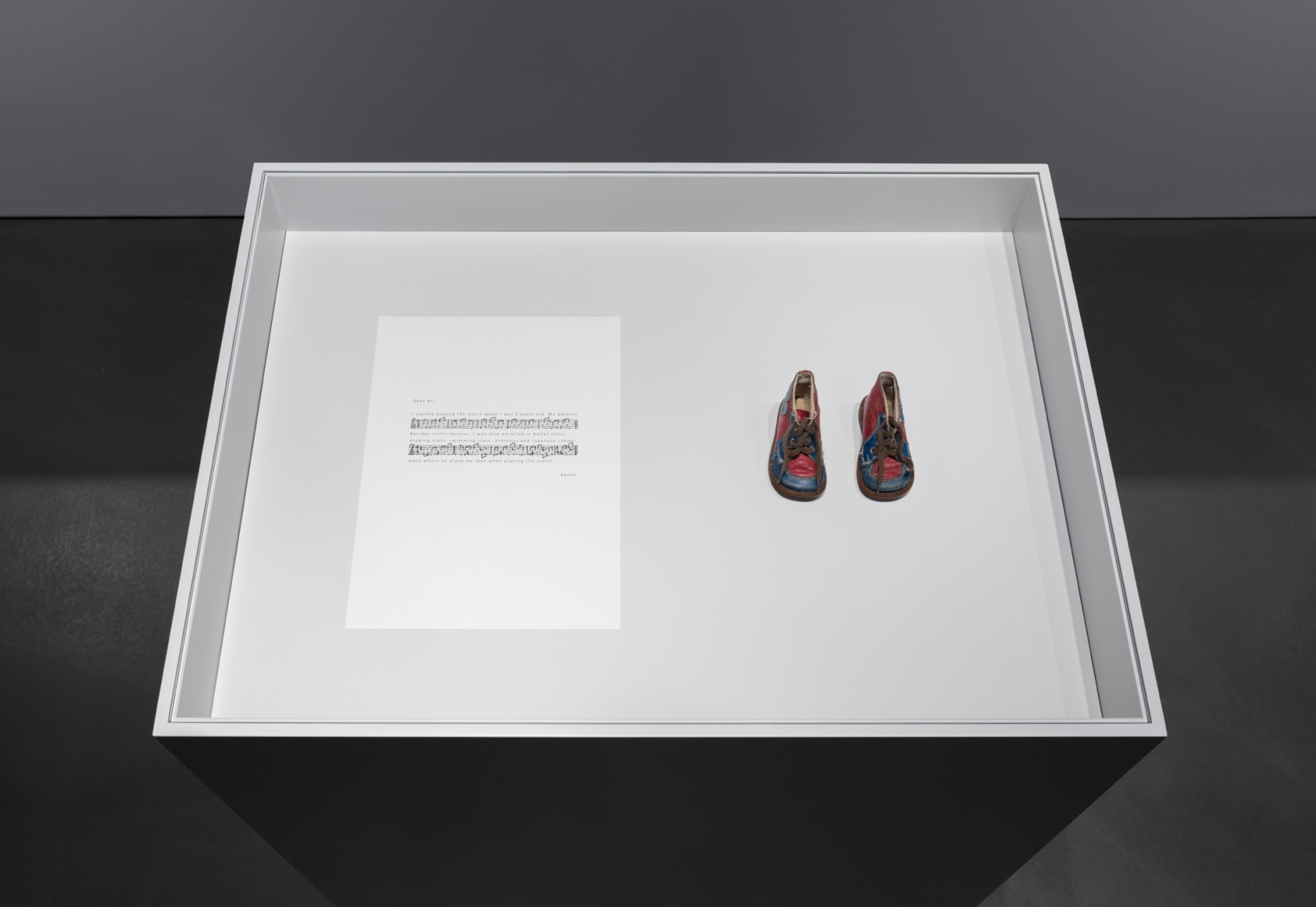 Solo for Ayumi (baby shoes), 2017 Handwritten score on paper, baby shoes, plinth A pair of used baby shoes—a relic...