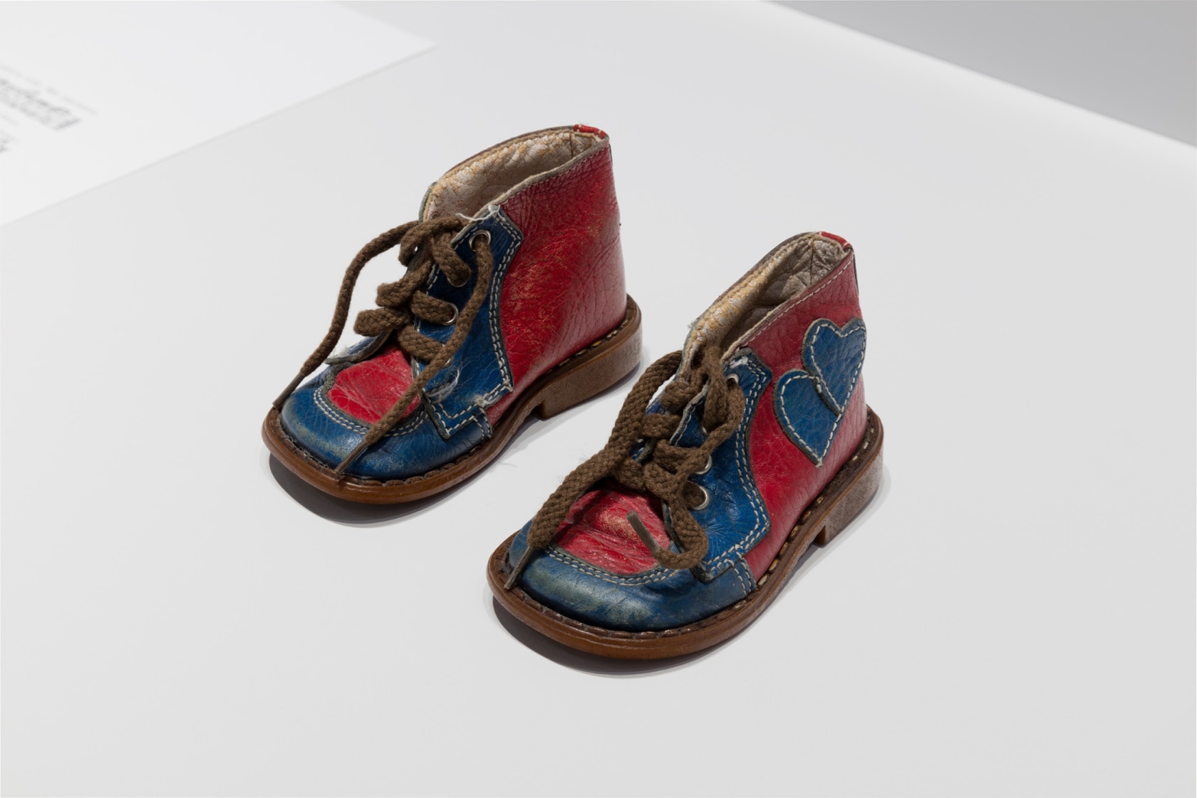 Solo for Ayumi (baby shoes), 2017 (detail) Handwritten score on paper, baby shoes, plinth A pair of used baby shoes—a...