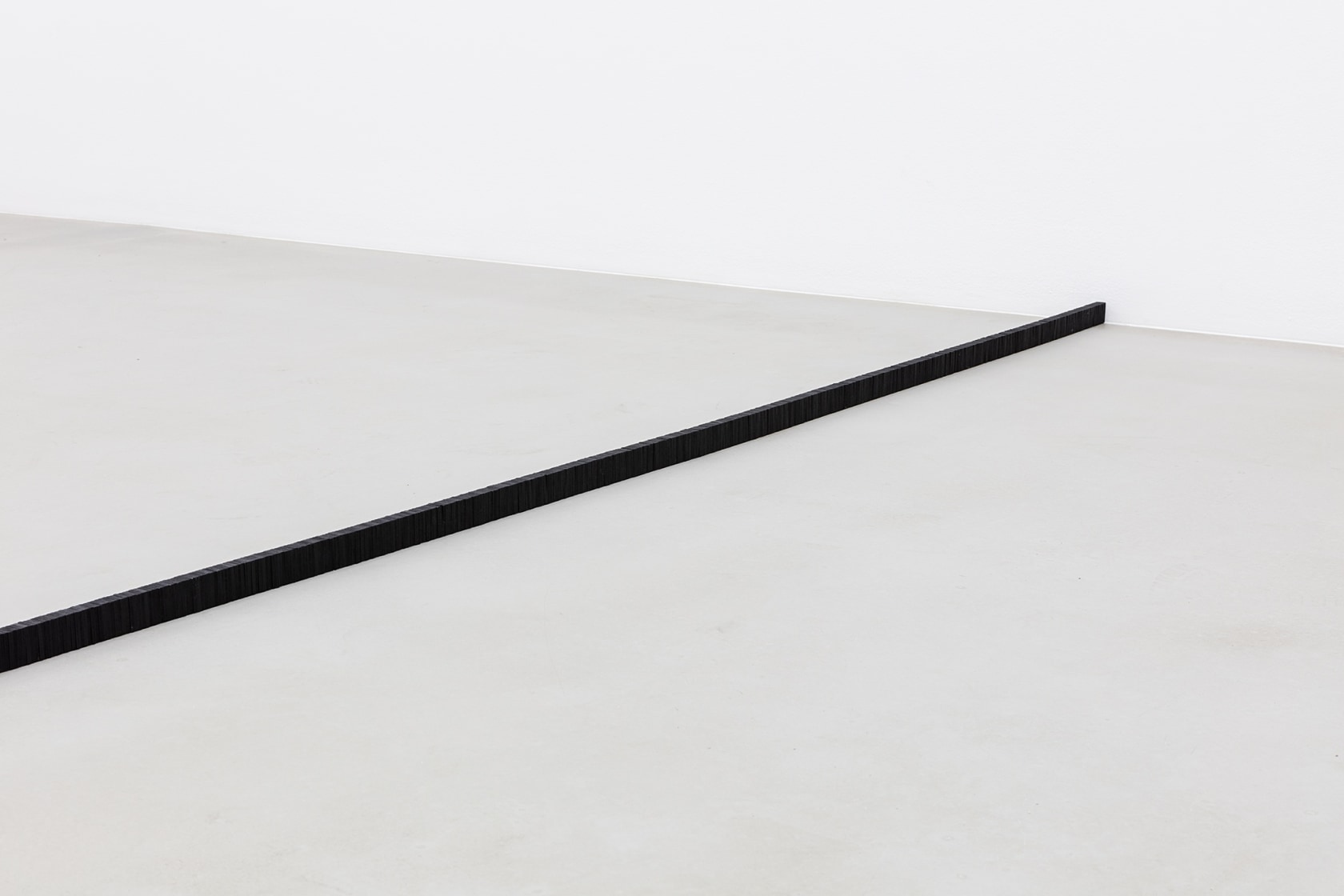 Domino Effect, 2015 Domino tiles A narrow row of black wooden pieces are assembled from seemingly countless Domino tiles. Photo...