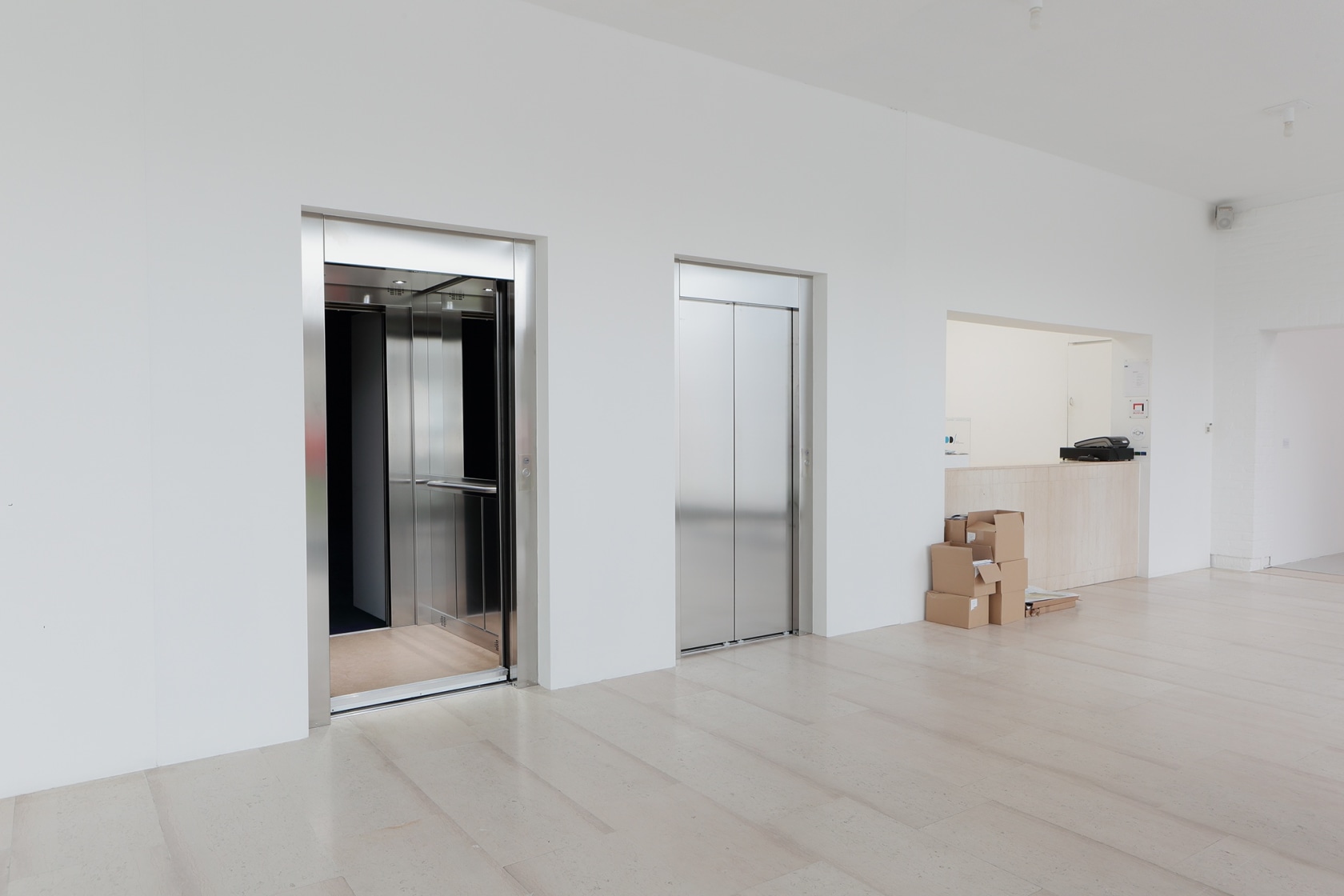 Two metal doors resembling elevators. One is permanently closed, the other appears stuck open, as its inside oor is slightly...
